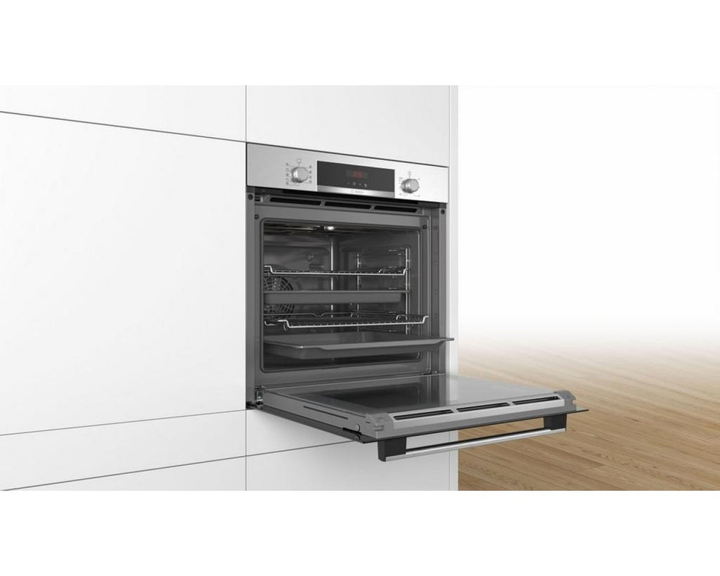 Bosch HBS573BSOB Pyro Single Oven - Stainless Steel - front view of appliance at an angle installed in an empty kitchen space as an integrated unit