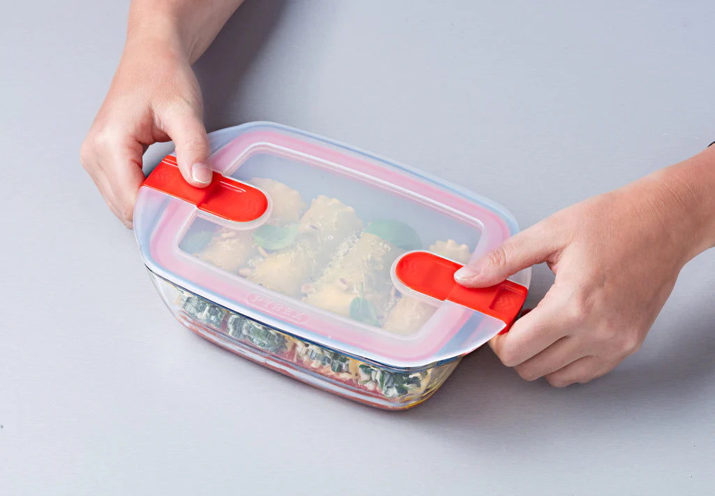 Pyrex Cook & Heat Rectangular 2.6L with food in it and someone showing how to open it.
