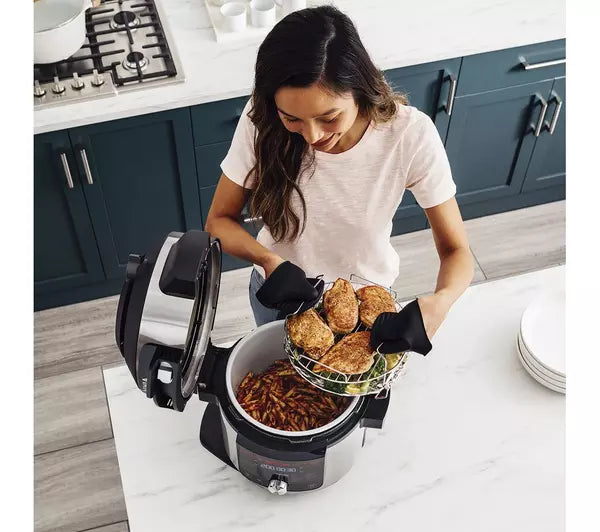 Woman putting out food from ninja Multi-Cooker & Pressure Cooker