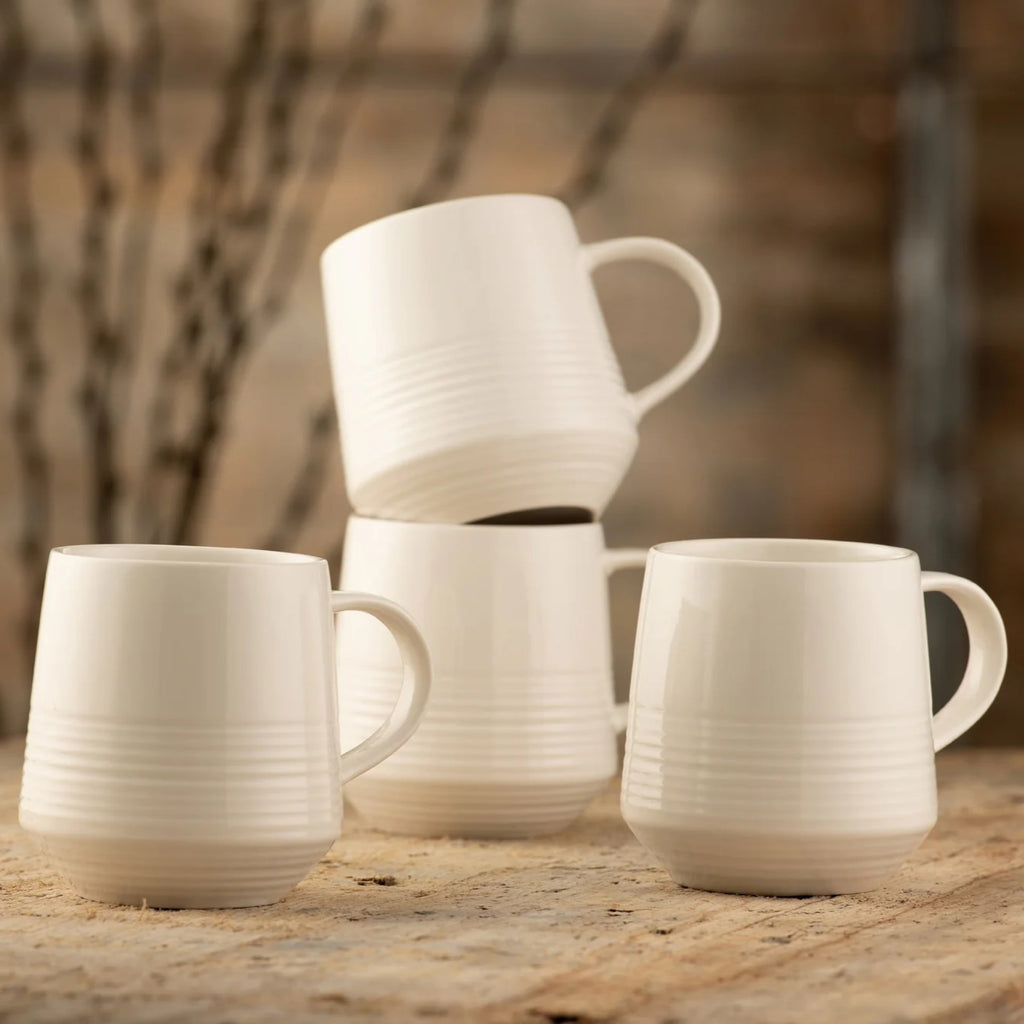 Belleek 9415 Zephyr Mug Set of 4 - Zephyr mugs placed on a wooden table with two of the mugs stacked