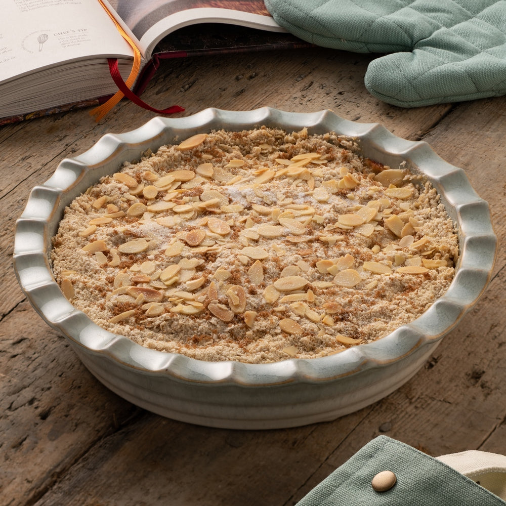 Belleek Tivoli Pie Dish pictured with a bake inside the dish, placed on a wooden table