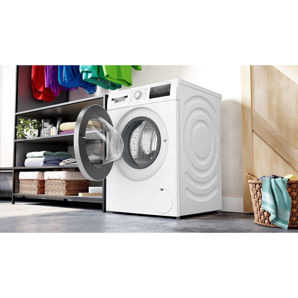 Bosch WAN28259GB Washing Machine 9kg 1400 Spin - Bosch washing machine placed in a house interior with front washing machine door open and clothes storage with towels arrayed around the machine