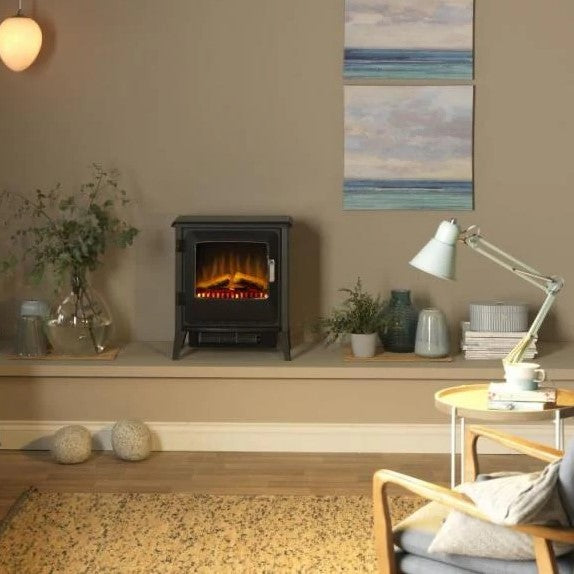 Dimplex LUC20 Lucia Stove LED Optiflame - view of electric stove fire placed in a furnished home interior with plants, vases, tables, table lamps and a chair