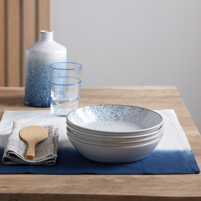 Lifestyle image of Kiln Blue pasta bowl sitting on a dressed table