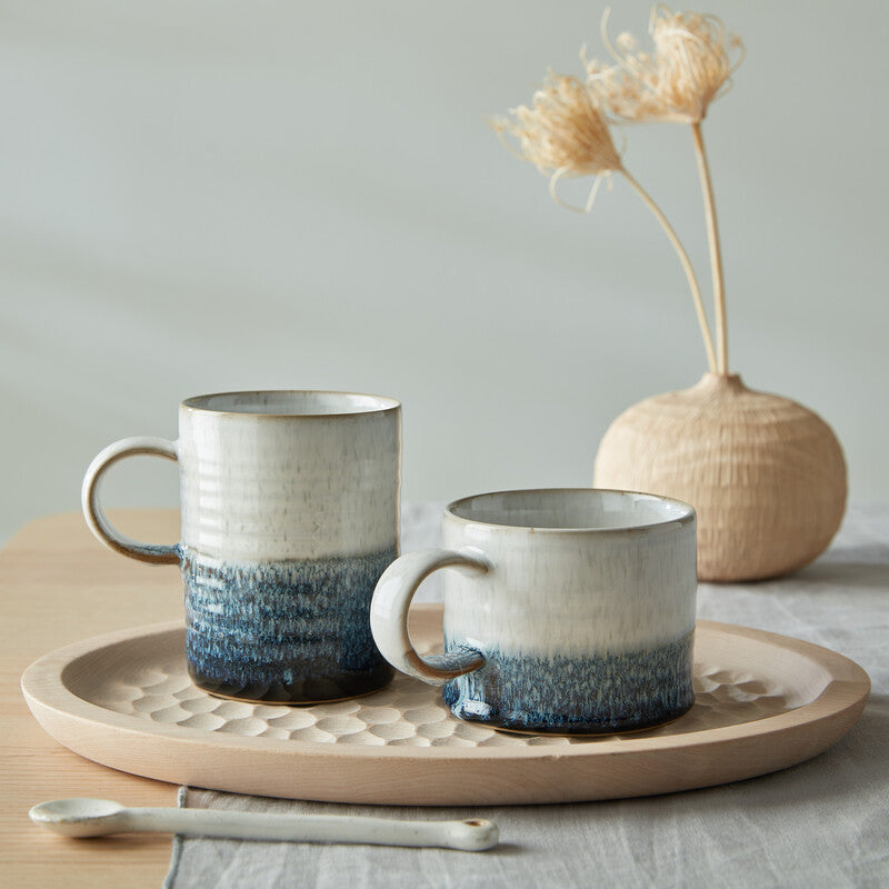 Lifestyle picture of the 2 Kiln Blue mugs that are available in the pattern