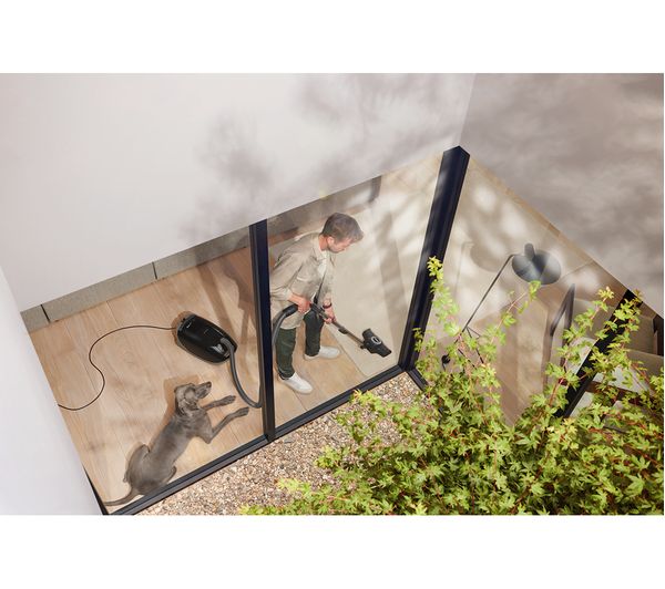 Man using MIELE Guard M1 Cat & Dog Cylinder Bagged Vacuum Cleaner - Black