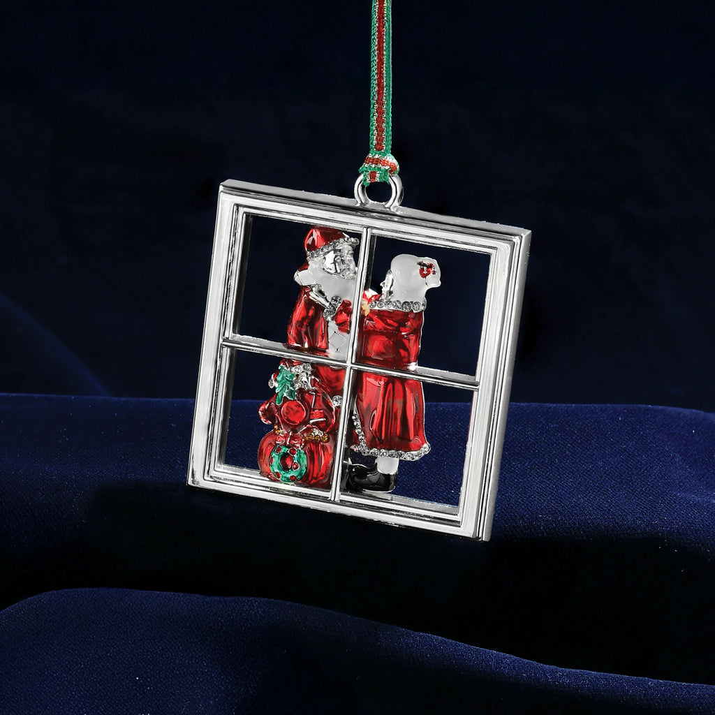 Decorative Christmas ornament with Santa Claus and a wreath through a window on a dark background.