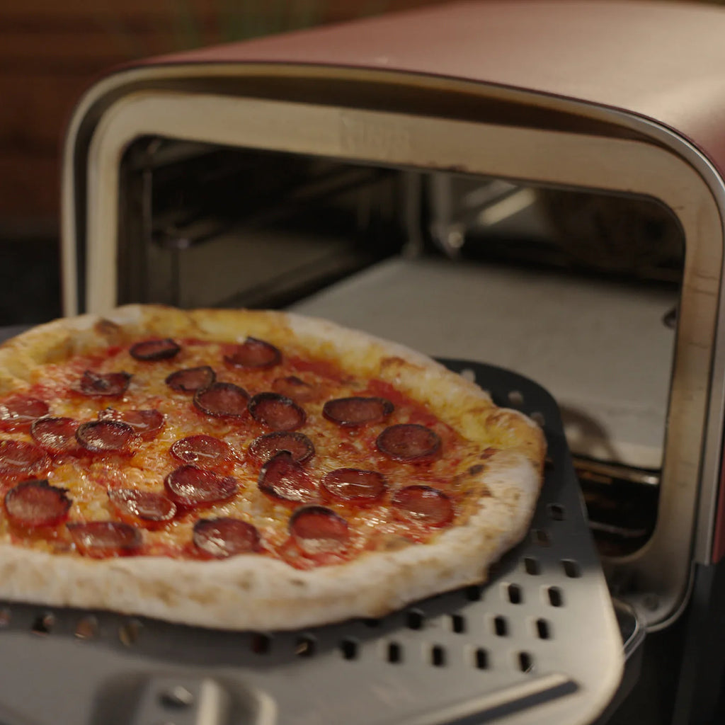 Ninja OO101 Outdoor Oven - picture of the Ninja oven being used to put a pizza inside