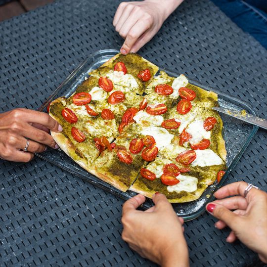 Pyrex Baking Tray 32x26cm 291B000 with a savoury dish on it and people taking a piece.