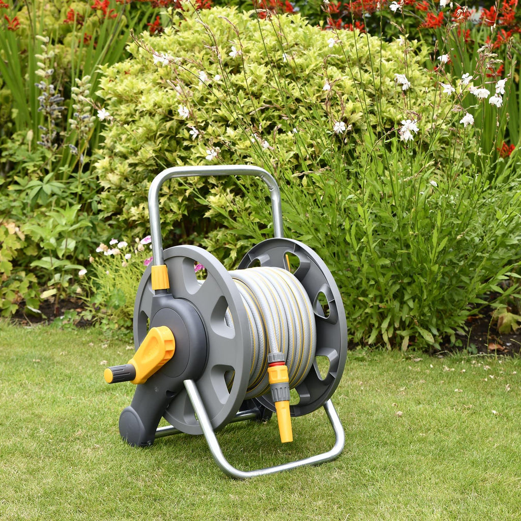 Hozelock 2431 Hose Reel 2 in 1, 25m Wall Mounted or Free Standing sitting in a garden