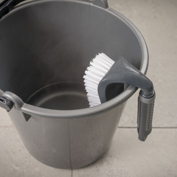 Addis 517700 Comfi Grip Iron Hand Scrub,  Graphite hanging over a bucket