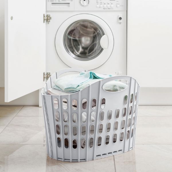 Addis 518163 Fold Flat Laundry Basket Green & Grey sitting full off clothes beside the washing machine
