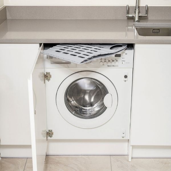 Addis 518163 Fold Flat Laundry Basket Green & Grey folded flat and sitting on top  off the washing machine