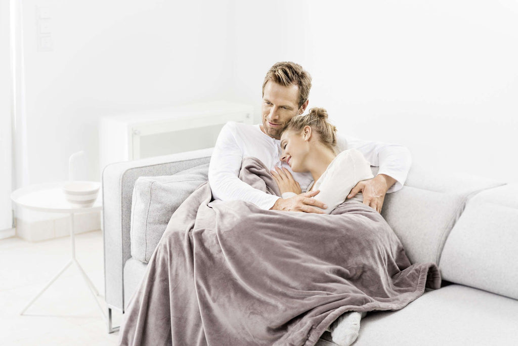 Couple wearing Cosy Heated Snuggle Throw Taupe