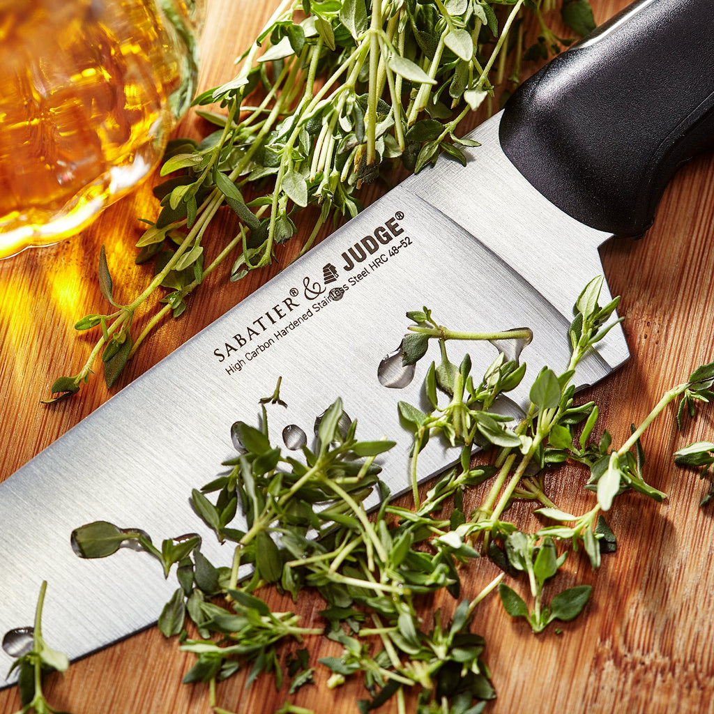 Judge Knife from the IP60 block on a wooden board with herbs
