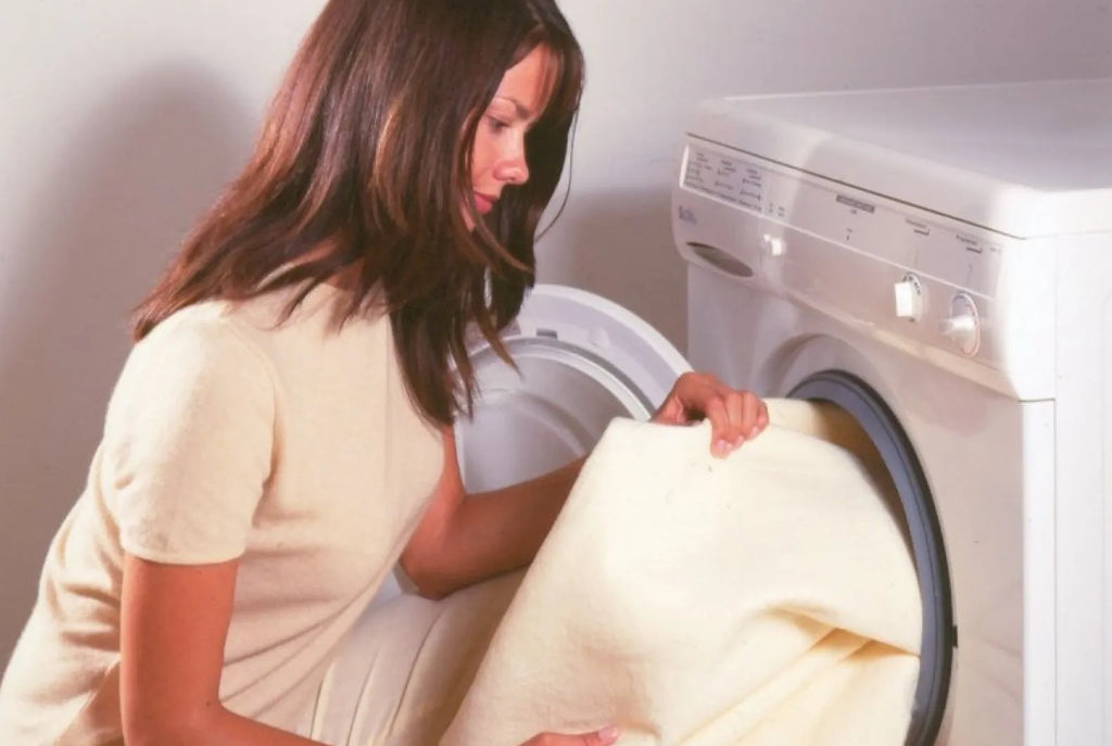 Woman placing Electric Underblanket inside the washing machine